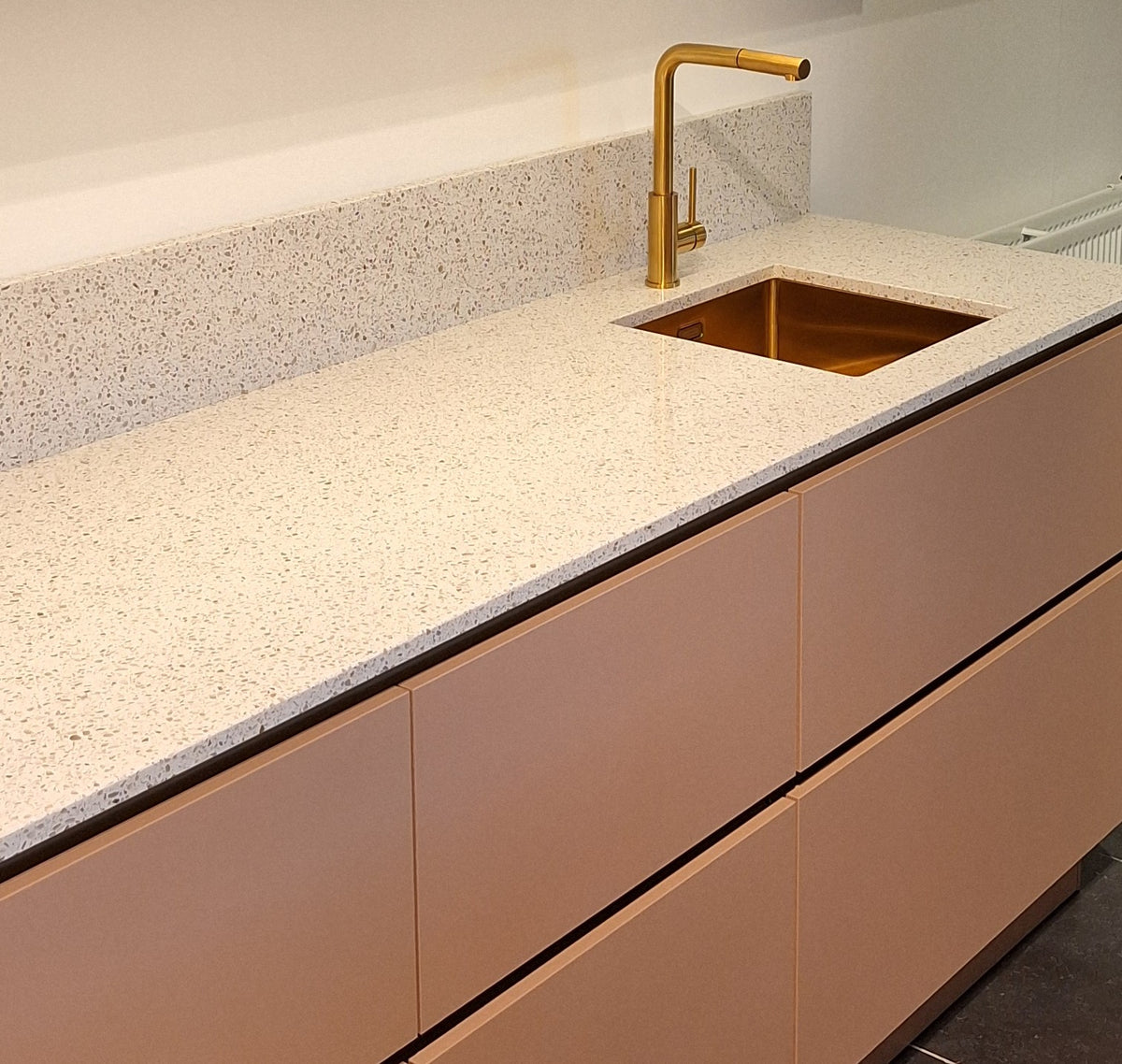 Koraalroze keuken met taupe hoge kastenwand inclusief koffiecorner