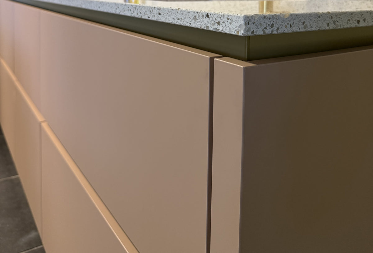Koraalroze keuken met taupe hoge kastenwand inclusief koffiecorner