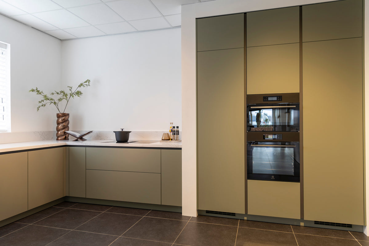 Olijfkleurige lakkeuken in hoekopstelling met Oscura composiet werkblad