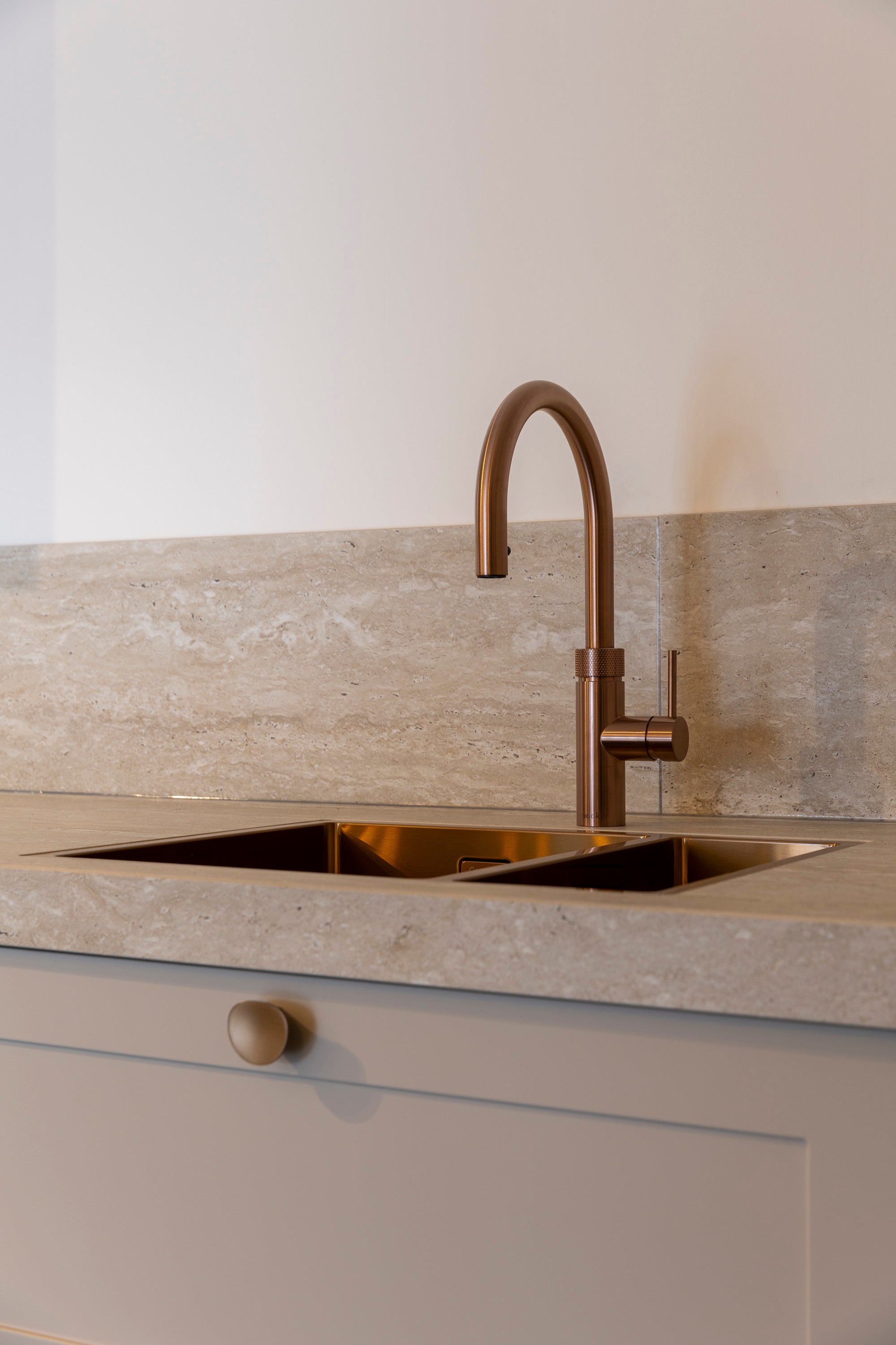 Lichte keuken met keramiek werkblad en koperen details