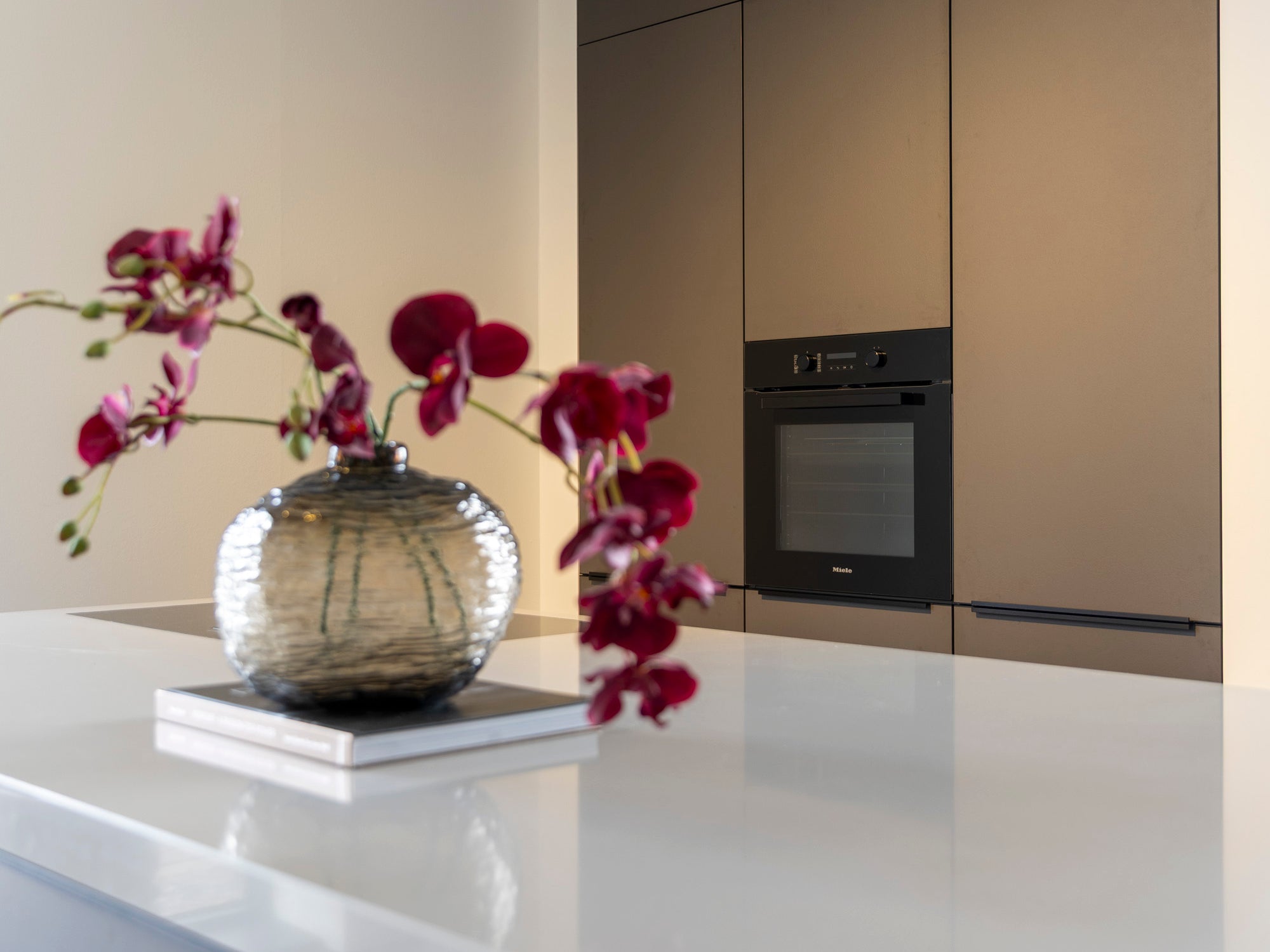 Coffee-kleur fronten met composiet werkblad en Miele-apparatuur