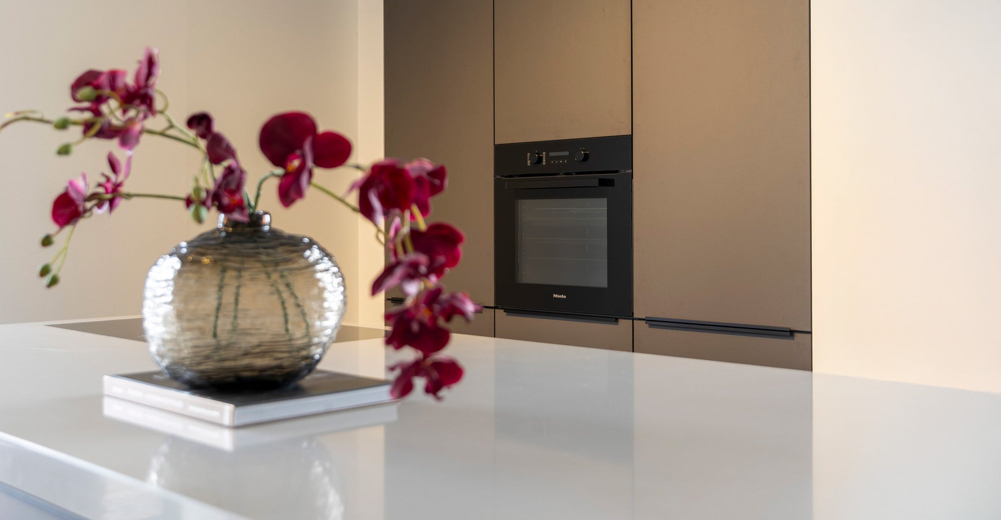 Coffee-kleur fronten met composiet werkblad en Miele-apparatuur