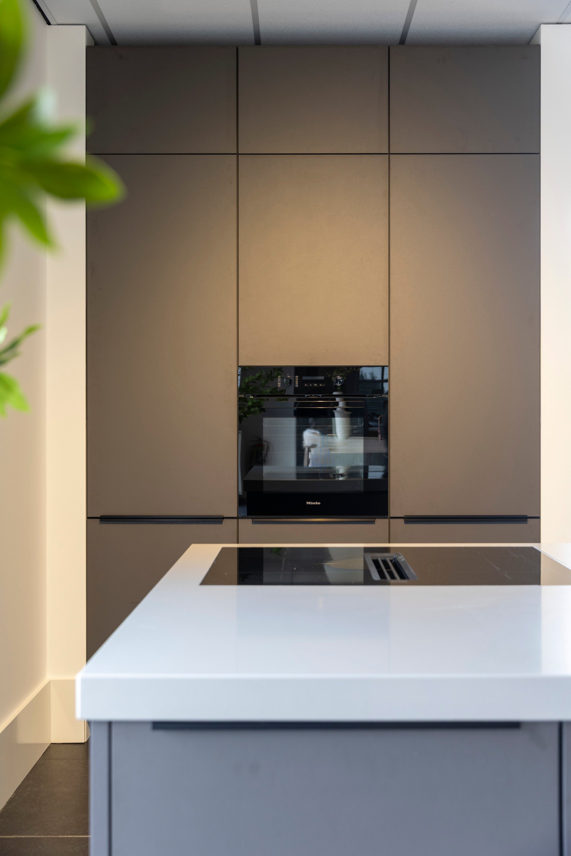 Coffee-kleur fronten met composiet werkblad en Miele-apparatuur