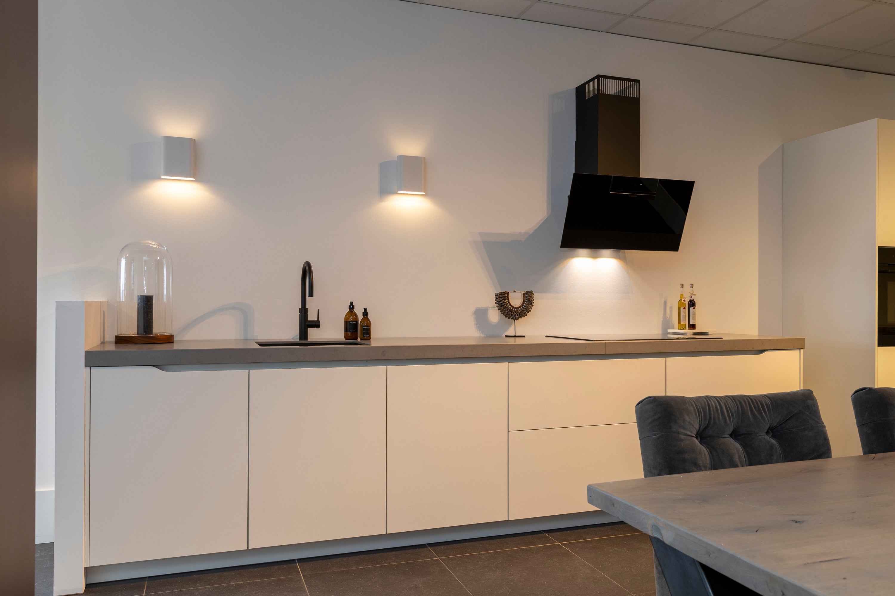 Wit gelakte wandkeuken met composiet werkblad en zwarte accenten