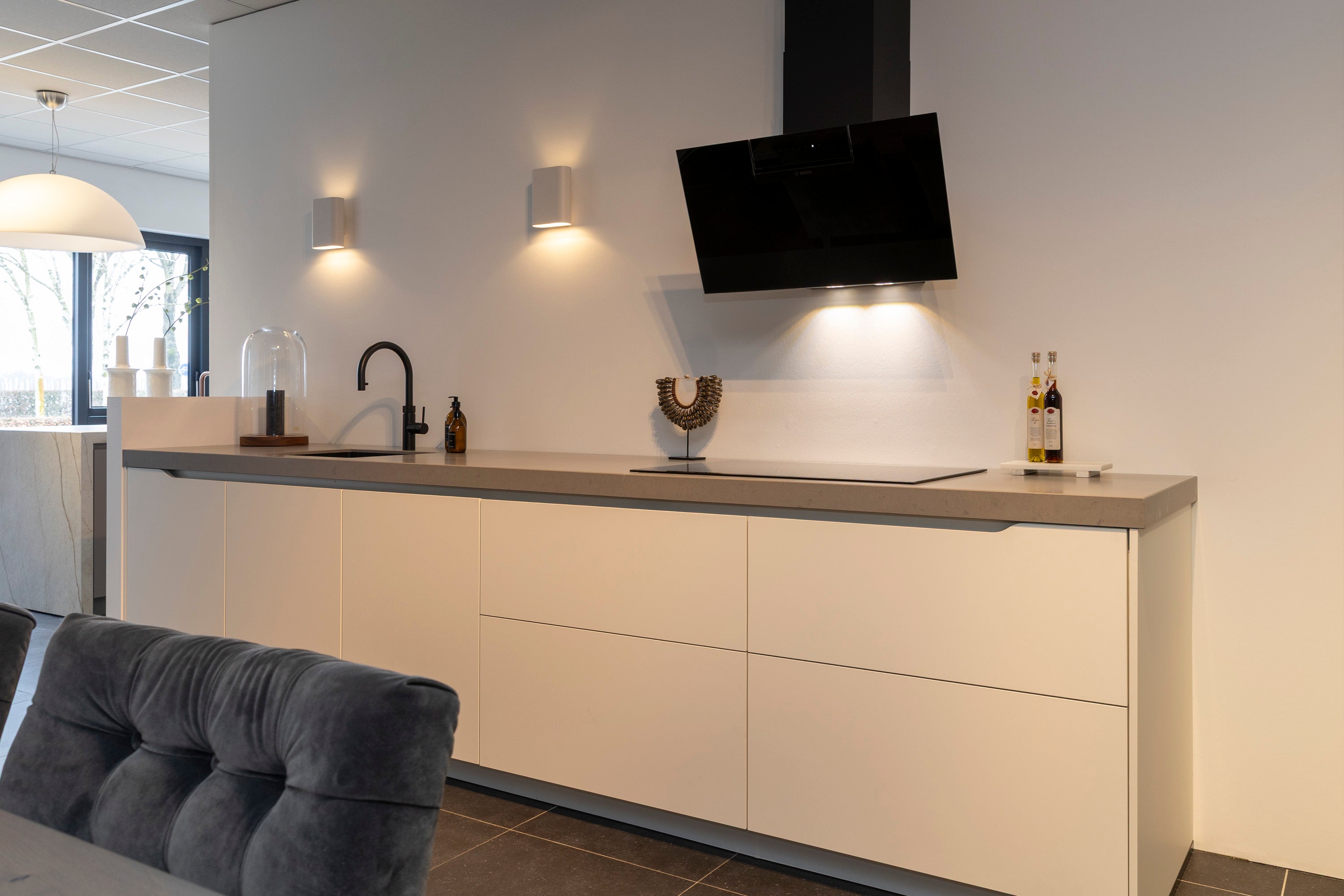 Wit gelakte wandkeuken met composiet werkblad en zwarte accenten