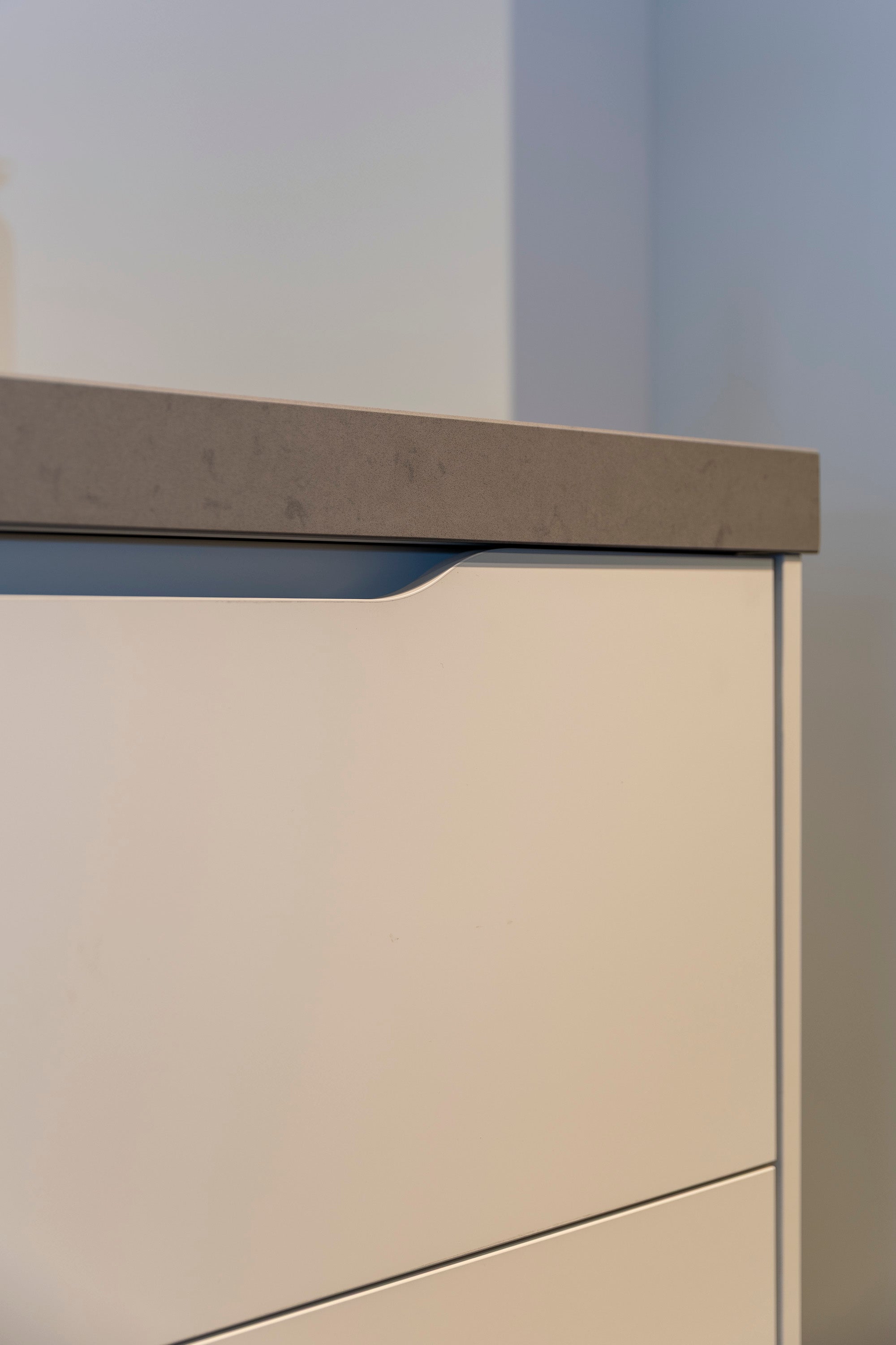 Wit gelakte wandkeuken met composiet werkblad en zwarte accenten